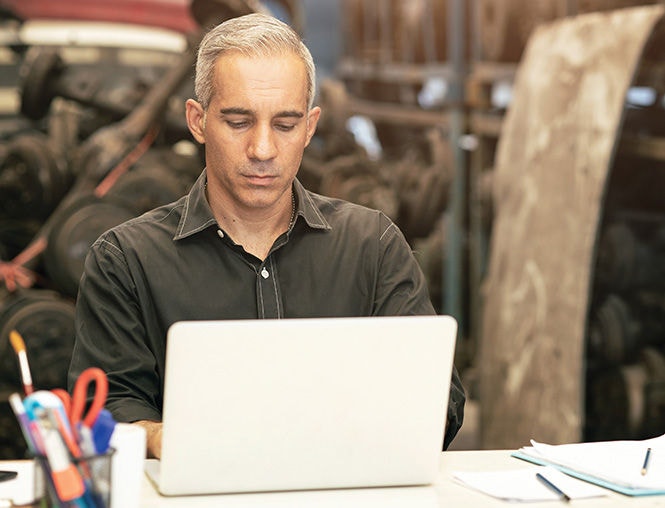Male employee taking an online training course on a laptop