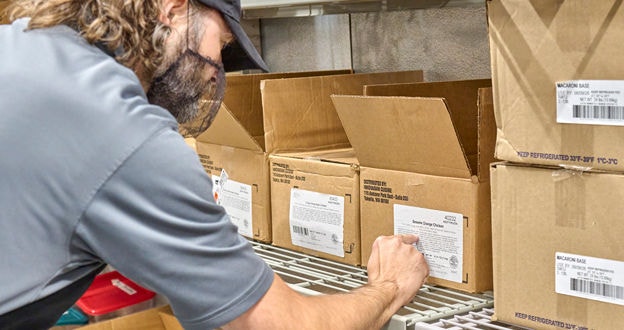 Person in refridgerated room checking food ingredients on side of box