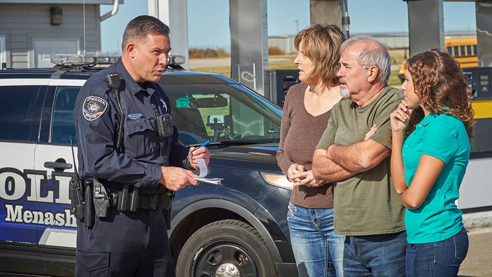 Police officer interacting with civilians during active threat or emergency situation.