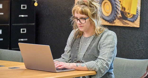 person in office space working on lap top doing training