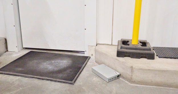 pest control trap placed along an interior building wall near a closed door way